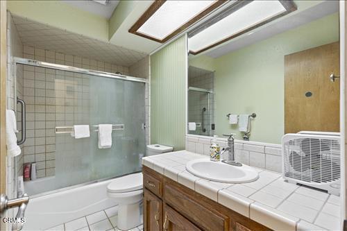 22820 Mariposa Rd, Tehachapi, CA 93561 - bathroom with vanity, tile patterned flooring, and combined bath / shower with glass door