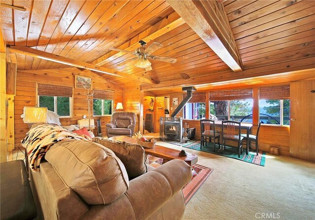 22052 Elliot Rd, Cedarpines Park, CA 92322 - carpeted living area featuring a wood stove, wood walls, wooden ceiling, and a ceiling fan