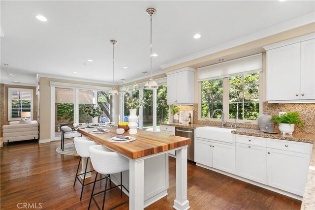 32 Tesoro, Irvine, CA 92618 - kitchen with stainless steel dishwasher, wooden counters, decorative backsplash, white cabinetry, and recessed lighting