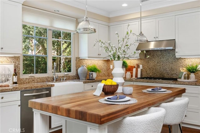 32 Tesoro, Irvine, CA 92618 - kitchen with butcher block countertops, under cabinet range hood, appliances with stainless steel finishes, white cabinets, and crown molding