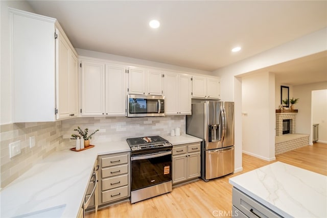 2455 Mcmackin Dr, Corona, CA 92881 - kitchen with stainless steel appliances, light wood finished floors, backsplash, light stone countertops, and recessed lighting