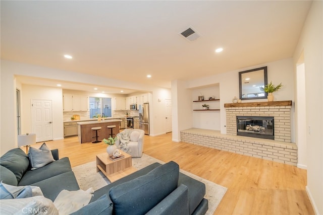 2455 Mcmackin Dr, Corona, CA 92881 - living area featuring light wood-type flooring, a fireplace, recessed lighting, and built in features
