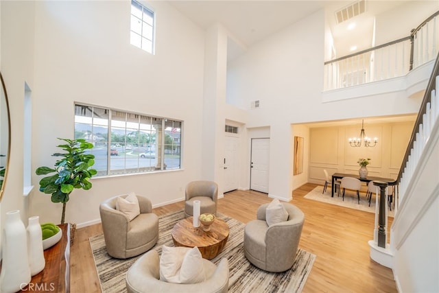2455 Mcmackin Dr, Corona, CA 92881 - living room featuring a high ceiling, light wood-style floors, stairs, and a chandelier