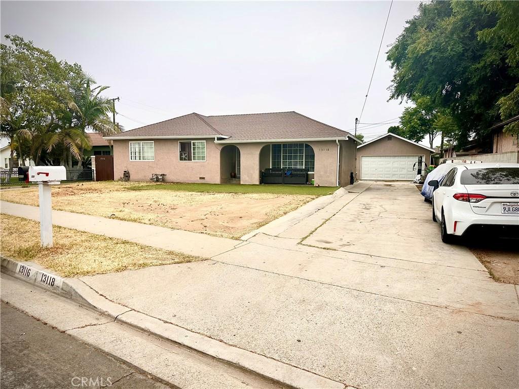 13118 Beaty Ave, Whittier, CA 90605 - view of front of house featuring stucco siding, a garage, and an outbuilding