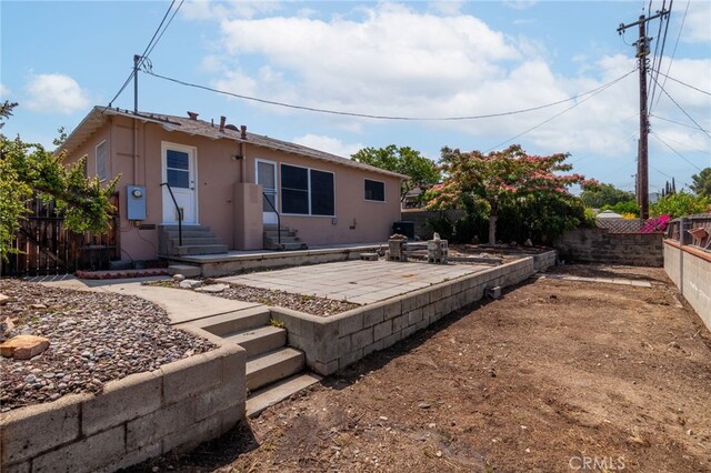 10935 Nassau Ave, Sunland, CA 91040 - rear view of property featuring entry steps, stucco siding, a fenced backyard, and a patio area