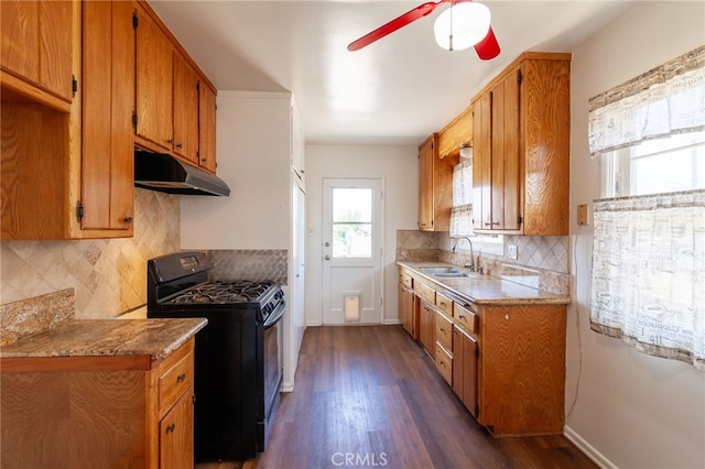 10935 Nassau Ave, Sunland, CA 91040 - kitchen with black range with gas stovetop, under cabinet range hood, ceiling fan, brown cabinetry, and dark wood-style flooring