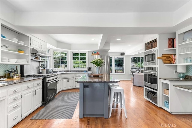 1733 Bayou Way, Seal Beach, CA 90740 - kitchen featuring appliances with stainless steel finishes, open shelves, backsplash, a center island, and white cabinets