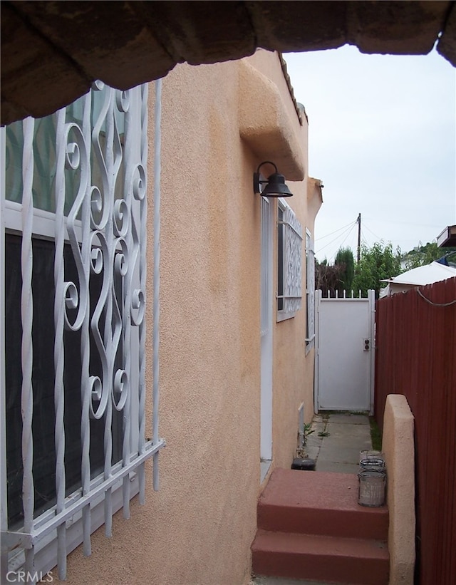 650 W 111th St, Los Angeles, CA 90044 - view of side of property with stucco siding and a gate