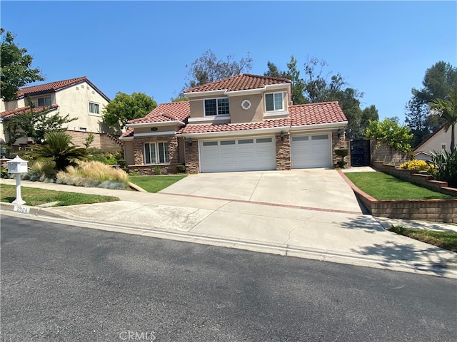 2304 Trickling Creek Dr, La Verne, CA 91750 - mediterranean / spanish house with stone siding, a tile roof, driveway, stucco siding, and an attached garage