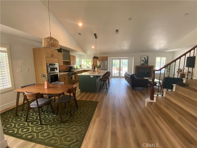 2304 Trickling Creek Dr, La Verne, CA 91750 - dining space featuring vaulted ceiling, wood finished floors, and stairway