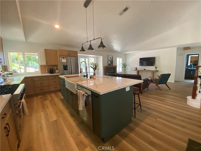 2304 Trickling Creek Dr, La Verne, CA 91750 - kitchen featuring appliances with stainless steel finishes, light wood-type flooring, vaulted ceiling, open floor plan, and a center island with sink