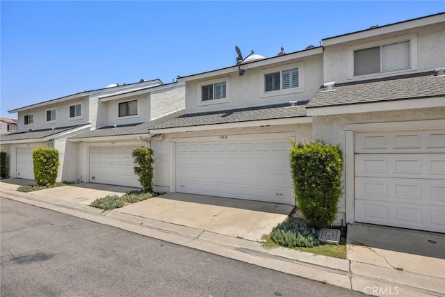 199 N Magnolia Ave Unit D, Anaheim, CA 92801 - townhome / multi-family property featuring stucco siding, a garage, a shingled roof, and driveway