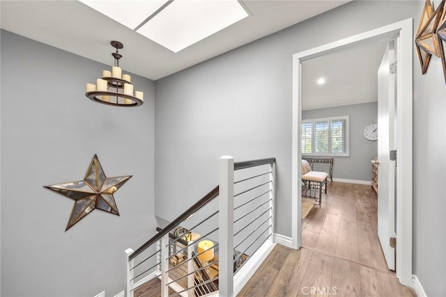 199 N Magnolia Ave Unit D, Anaheim, CA 92801 - hallway featuring an upstairs landing, hardwood / wood-style floors, a chandelier, and a skylight