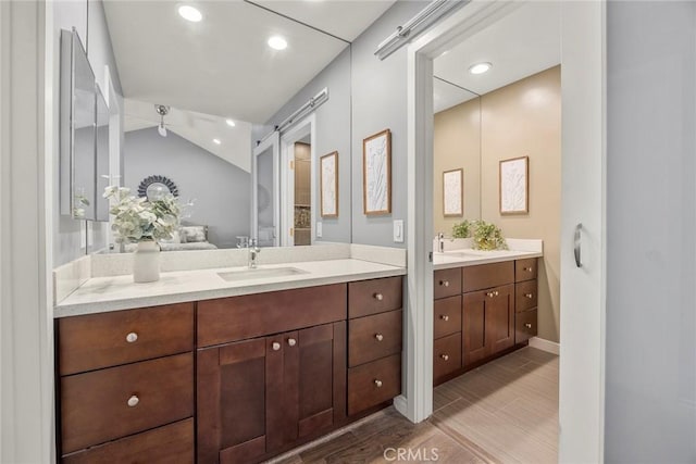 199 N Magnolia Ave Unit D, Anaheim, CA 92801 - full bathroom featuring two vanities, wood finished floors, lofted ceiling, and recessed lighting