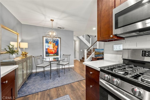 199 N Magnolia Ave Unit D, Anaheim, CA 92801 - kitchen featuring appliances with stainless steel finishes, light countertops, a chandelier, and tasteful backsplash