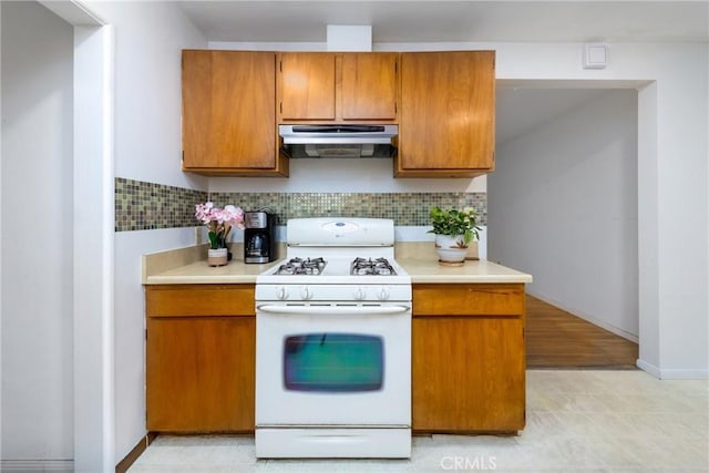 5064 N Berkeley Ave, San Bernardino, CA 92407 - kitchen featuring white range with gas stovetop, exhaust hood, light countertops, and brown cabinets