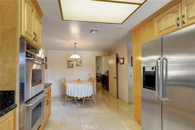 872 Deborah St, Upland, CA 91784 - kitchen featuring stainless steel appliances, dark countertops, light brown cabinetry, light tile patterned floors, and a chandelier