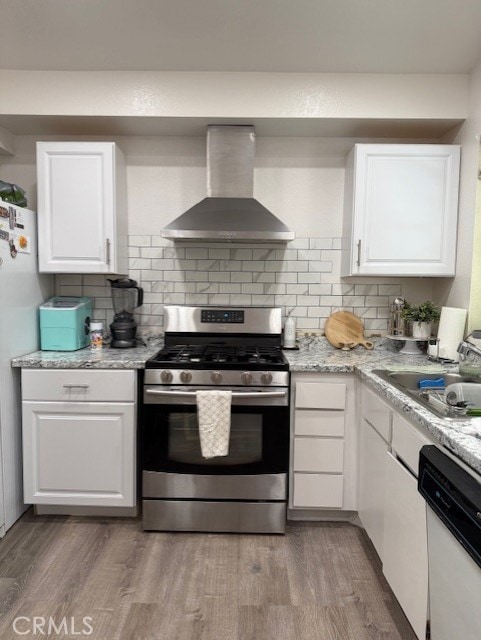 12446 Mount Baldy Dr, Victorville, CA 92392 - kitchen featuring stainless steel gas range, wall chimney exhaust hood, white dishwasher, light wood-style flooring, and white cabinetry