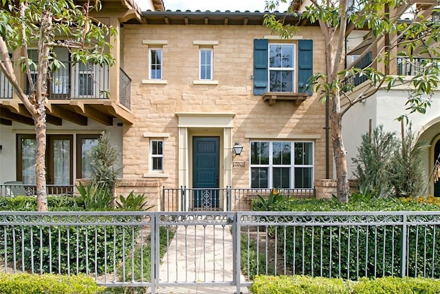 760 S Olive St, Anaheim, CA 92805 - view of front of home featuring a fenced front yard, a balcony, and stone siding
