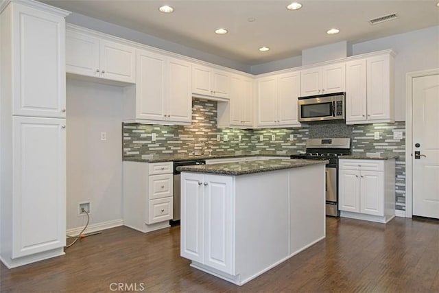 760 S Olive St, Anaheim, CA 92805 - kitchen featuring appliances with stainless steel finishes, dark wood-type flooring, white cabinetry, tasteful backsplash, and recessed lighting