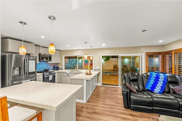 2040 Cape Cod Ct, Claremont, CA 91711 - kitchen featuring stainless steel appliances, open floor plan, a peninsula, light countertops, and a breakfast bar area