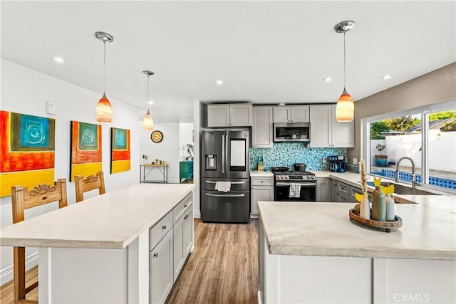 2040 Cape Cod Ct, Claremont, CA 91711 - kitchen with stainless steel appliances, light wood-style floors, gray cabinets, backsplash, and a peninsula