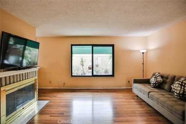 8458 Evergreen, Garden Grove, CA 92841 - living room featuring wood finished floors, a textured ceiling, and a fireplace with flush hearth