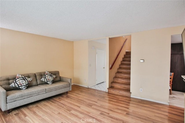 8458 Evergreen, Garden Grove, CA 92841 - living area with light wood finished floors, stairway, and a textured ceiling