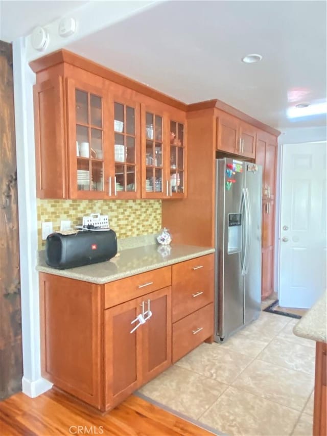 9849 Canada Way, Riverside, CA 92503 - kitchen with stainless steel fridge, glass insert cabinets, backsplash, and brown cabinets