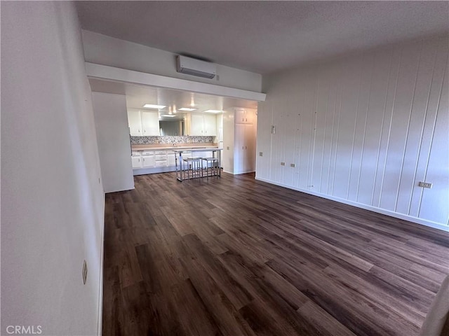 1271 Kenwood Unit 163D, Seal Beach, CA 90740 - unfurnished living room featuring a wall mounted AC and dark wood-type flooring