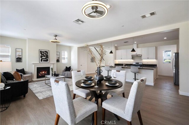 30316 Slate St, Murrieta, CA 92563 - dining room with healthy amount of natural light, light wood-style floors, and a lit fireplace