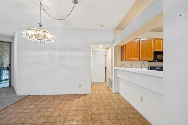 1441 Brett Pl Unit 148, San Pedro, CA 90732 - kitchen with a chandelier, black microwave, hanging light fixtures, stove, and brown cabinets