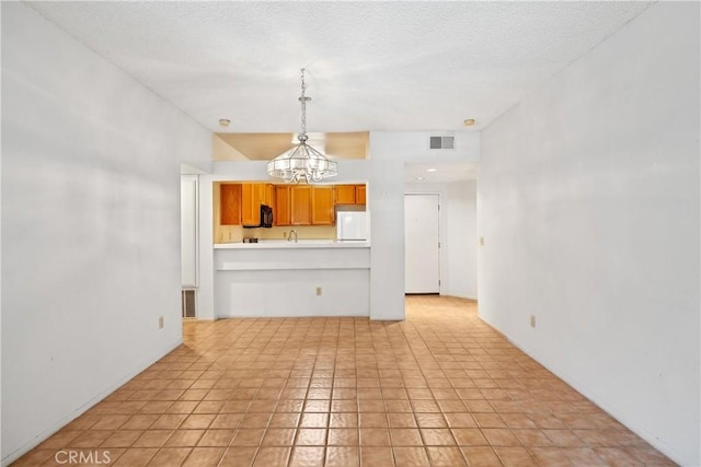 1441 Brett Pl Unit 148, San Pedro, CA 90732 - kitchen with a chandelier, fridge, light countertops, pendant lighting, and a textured ceiling