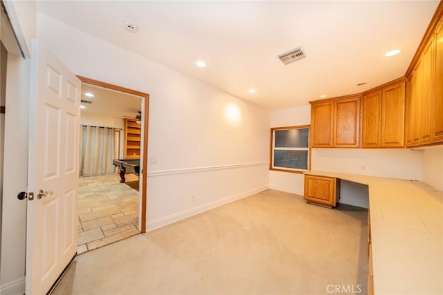533 Via Vista Dr, Redlands, CA 92373 - kitchen with built in study area, recessed lighting, brown cabinets, light countertops, and light colored carpet