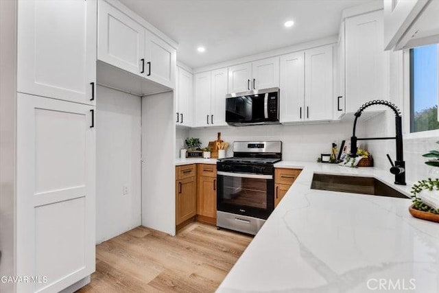 36848 Apache Plume Dr, Palmdale, CA 93550 - kitchen featuring stainless steel gas stove, light wood-style flooring, light stone countertops, white cabinets, and recessed lighting