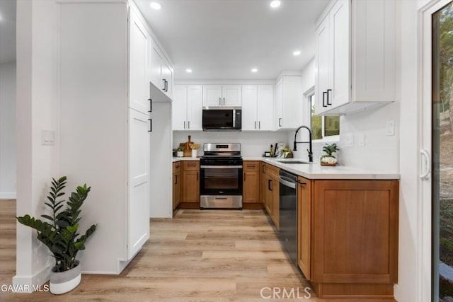 36848 Apache Plume Dr, Palmdale, CA 93550 - kitchen featuring appliances with stainless steel finishes, light wood finished floors, light countertops, recessed lighting, and white cabinetry