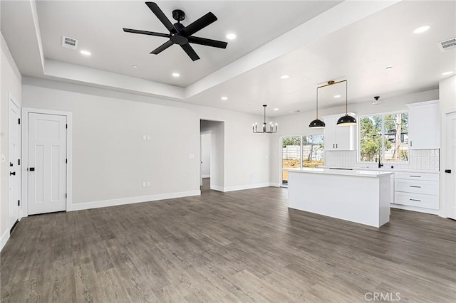 6388 Oak Rd, Paradise, CA 95969 - unfurnished living room featuring a chandelier, a ceiling fan, dark wood-style flooring, recessed lighting, and a tray ceiling
