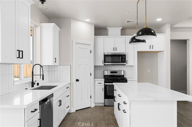 6388 Oak Rd, Paradise, CA 95969 - kitchen with appliances with stainless steel finishes, a center island, white cabinets, dark wood finished floors, and tasteful backsplash