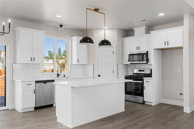 6388 Oak Rd, Paradise, CA 95969 - kitchen featuring appliances with stainless steel finishes, white cabinetry, light countertops, wood finished floors, and recessed lighting