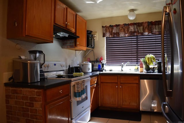 384 I St, Chula Vista, CA 91910 - kitchen featuring appliances with stainless steel finishes, brown cabinetry, light tile patterned flooring, and under cabinet range hood