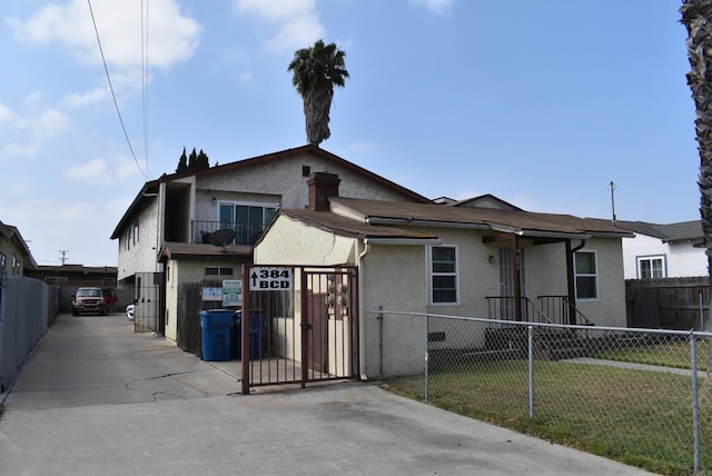 384 I St, Chula Vista, CA 91910 - view of front facade featuring stucco siding and a gate