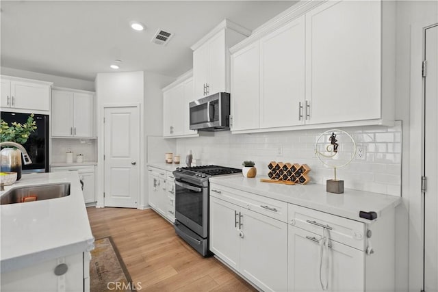 2239 Melogold Way, Corona, CA 92883 - kitchen featuring appliances with stainless steel finishes, light countertops, white cabinetry, recessed lighting, and decorative backsplash