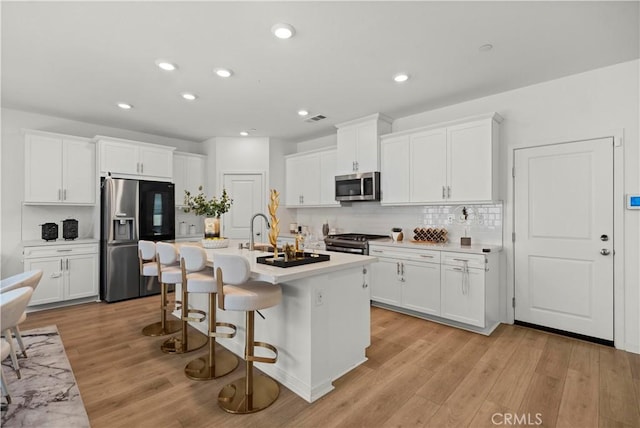 2239 Melogold Way, Corona, CA 92883 - kitchen featuring stainless steel appliances, white cabinets, light wood-style flooring, and recessed lighting