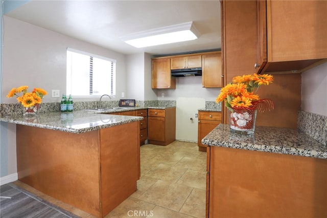 1818 W 145th St Unit 1, Gardena, CA 90249 - kitchen featuring under cabinet range hood, brown cabinets, a peninsula, and stone countertops