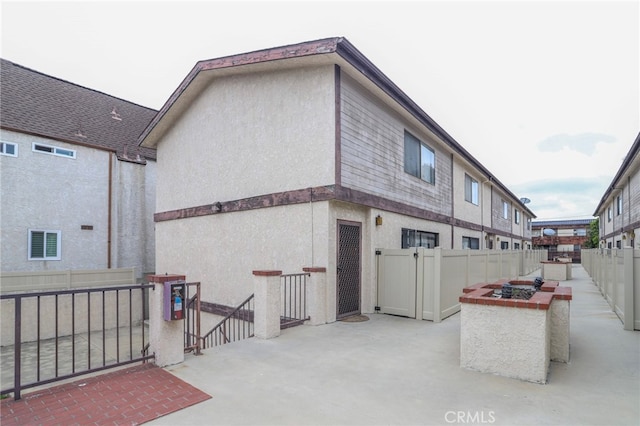 1818 W 145th St Unit 1, Gardena, CA 90249 - rear view of property featuring a fenced backyard, a patio, a gate, and stucco siding