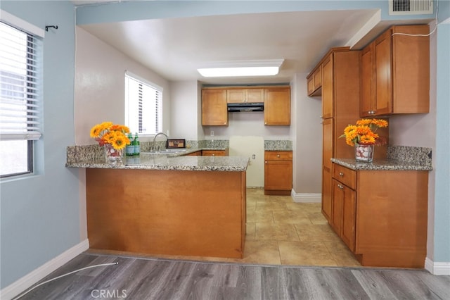 1818 W 145th St Unit 1, Gardena, CA 90249 - kitchen featuring under cabinet range hood, light stone countertops, and a peninsula