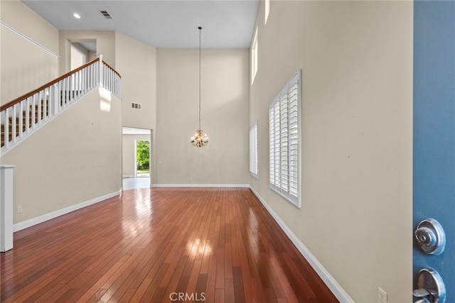 29243 Discovery Ridge Dr, Saugus, CA 91390 - unfurnished living room with hardwood / wood-style flooring, a chandelier, and a high ceiling