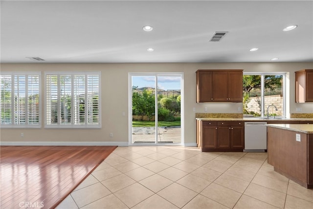 29243 Discovery Ridge Dr, Saugus, CA 91390 - kitchen with white dishwasher, healthy amount of natural light, recessed lighting, light stone countertops, and light tile patterned flooring