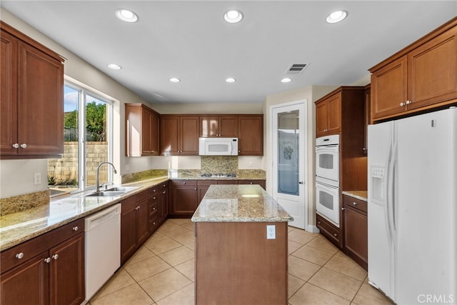 29243 Discovery Ridge Dr, Saugus, CA 91390 - kitchen with white appliances, a center island, light stone counters, backsplash, and recessed lighting