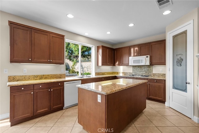 29243 Discovery Ridge Dr, Saugus, CA 91390 - kitchen with white appliances, light tile patterned flooring, a center island, recessed lighting, and light stone counters